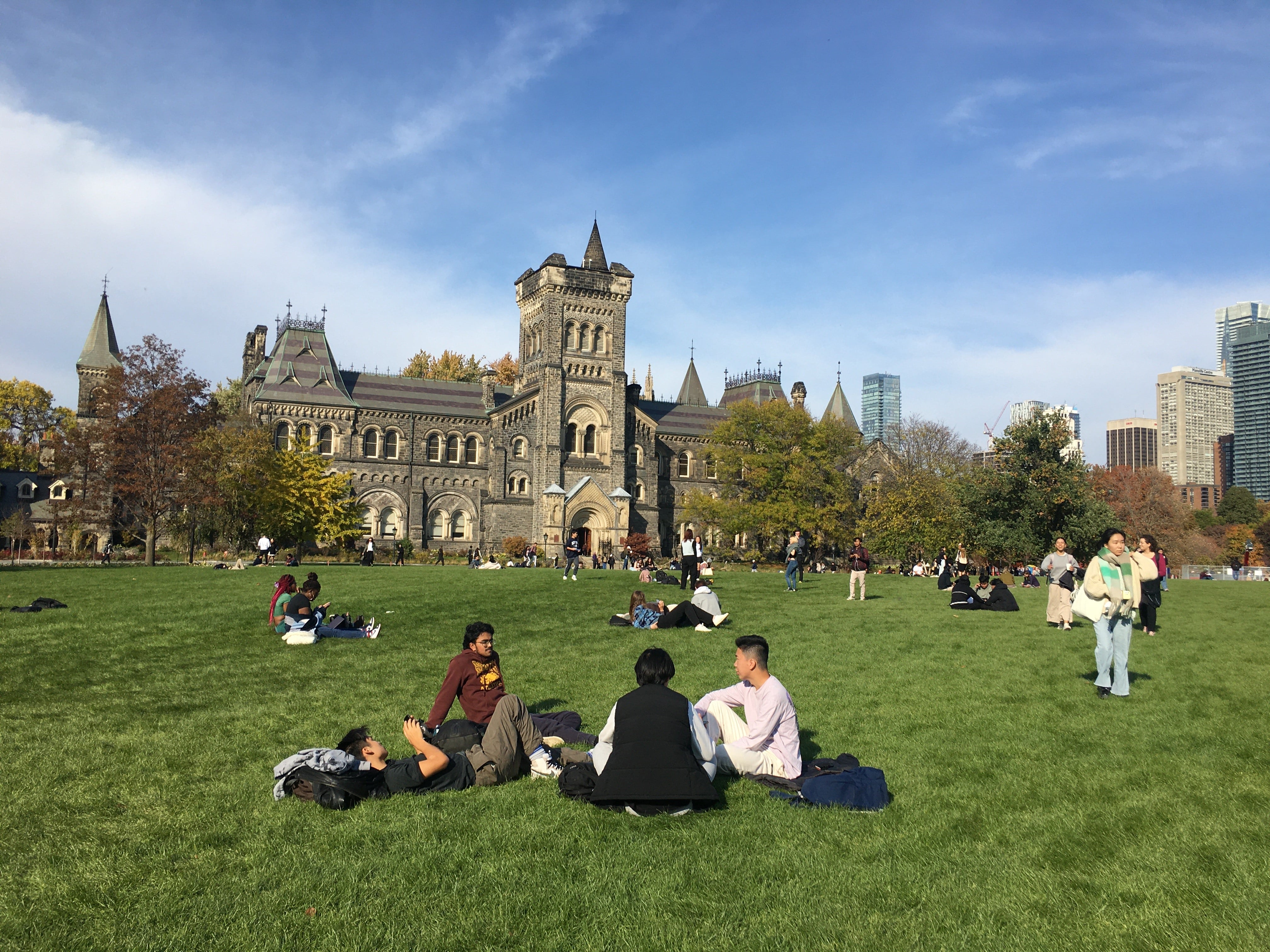 Students chatting on the field in front of University College building